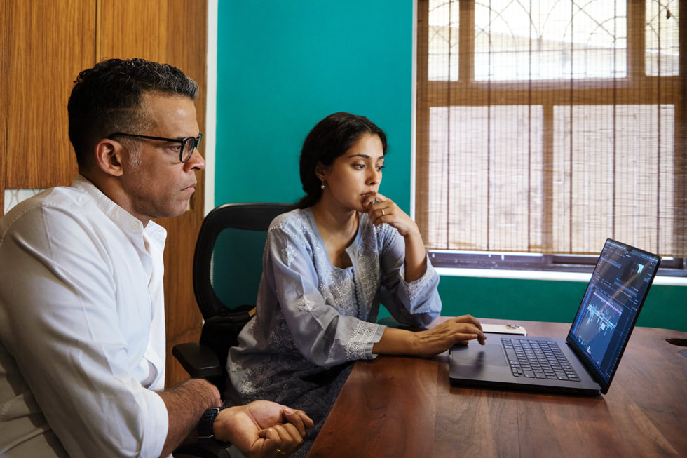 Amrita Bagchi con su mentor, Vikramaditya Motwane, miran el material en una MacBook Pro.