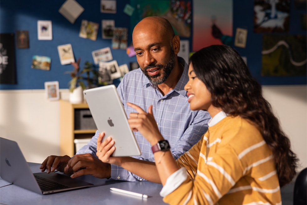 Une éducatrice coache un enseignant sur un iPad et un MacBook?Air.