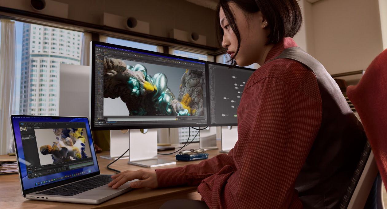 Bir ofis ortam?nda, Thunderbolt 5 ba?lant? noktas?yla Studio Display XDR’a ba?l? MacBook laptopta ?al??an bir ki?i