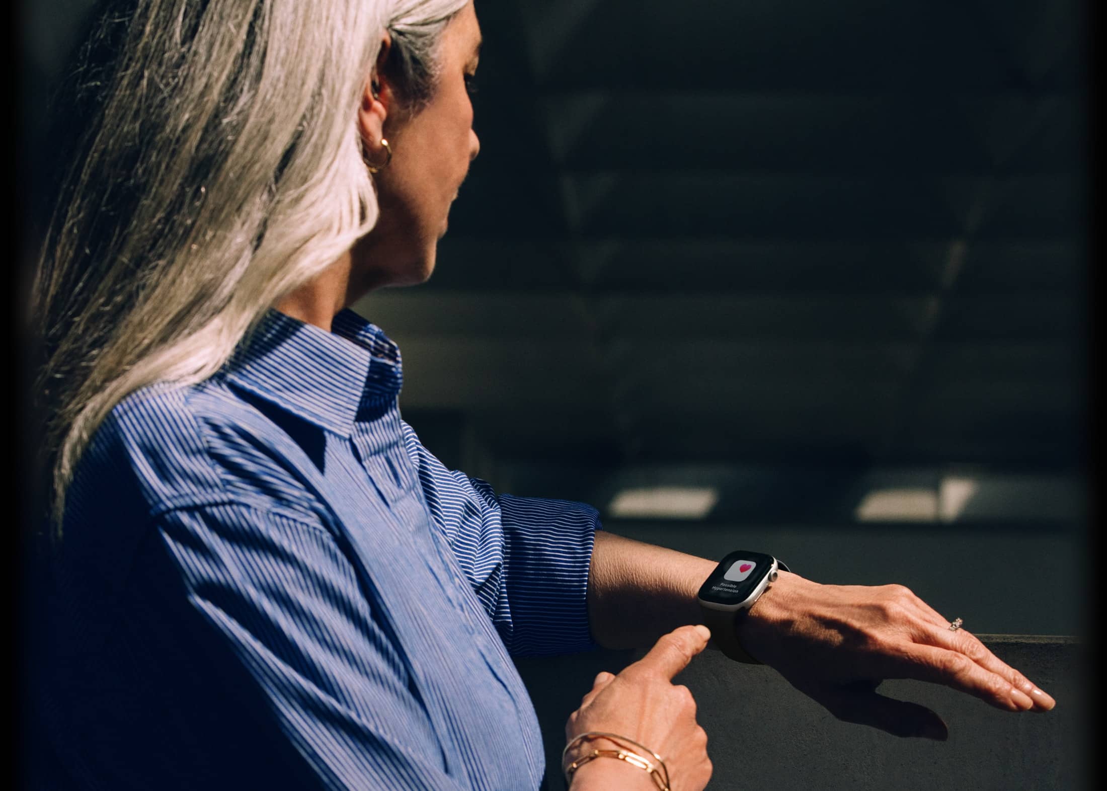 Cilvēks ar Apple Watch Series 11 lasa pazi?ojumu par hipertensiju