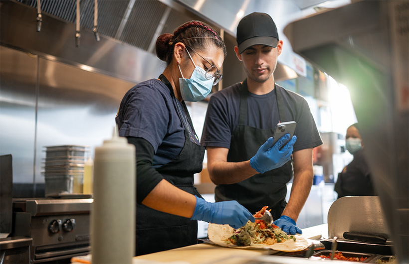 Une employée apprend à rouler un burrito ? fa?on Sisig ?.