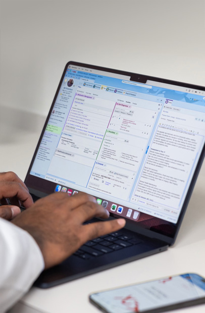 En sundhedsmedarbejder tjekker elektroniske patientjournaler p? en MacBook Pro.