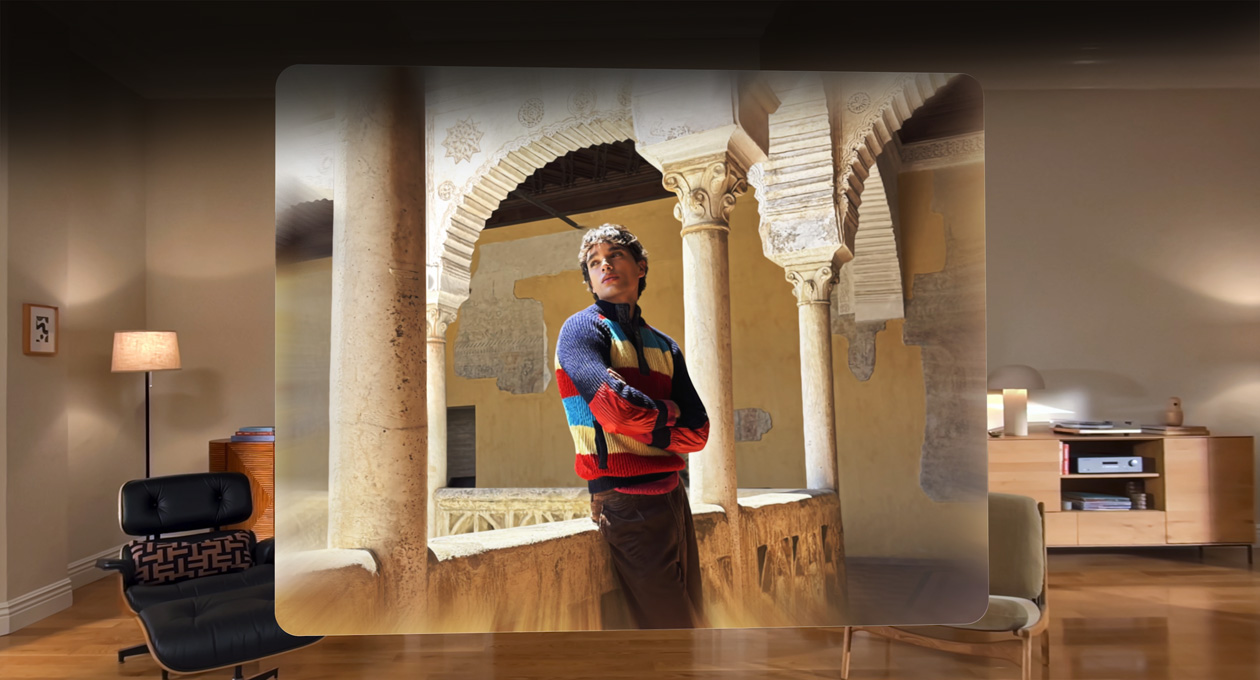Scène spatiale montrant la photo d’un homme appuyé contre le balcon d’une cour sinueuse, avec de la profondeur et du relief dans le cadre