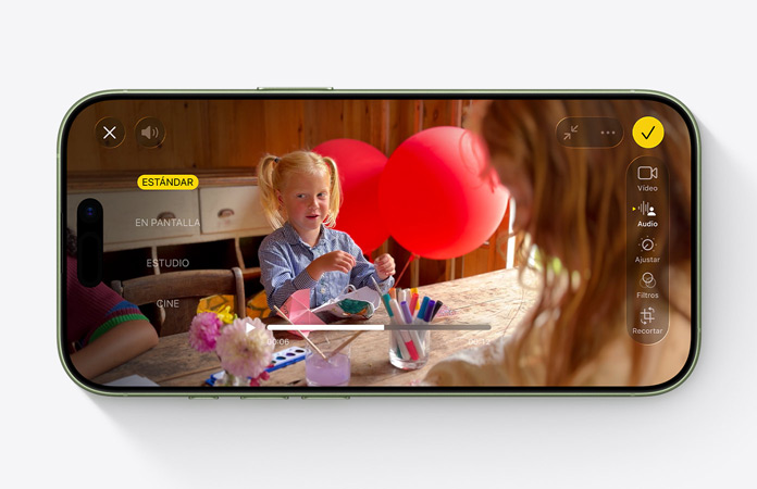 iPhone 17, parte delantera, vídeo de una ni?a en una mesa con globos con la prestación Mezcla de Audio en uso