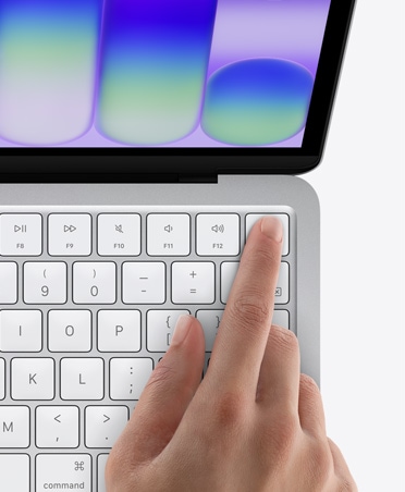 Sidabro spalvos ?MacBook Neo“, ?mogaus pir?tas ant ?Touch ID“ jutiklio klaviatūros de?iniame vir?utiniame kampe