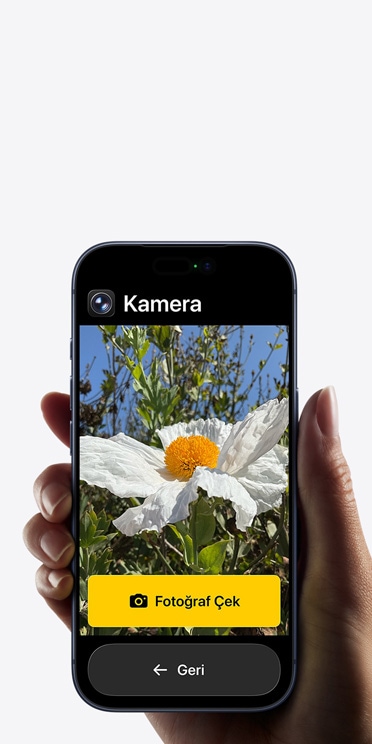 Kadraj?nda beyaz ?i?ek bulunan Kamera uygulamas?n?n basitle?tirilmi? arayüzünü, “Foto?raf ?ek” dü?mesini ve alt?ndaki “Geri” dü?mesini g?steren iPhone 17 Pro ekran?