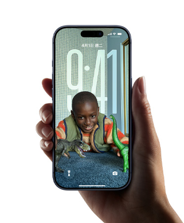 一隻手拿著 iPhone 裝置，展示全新 Liquid Glass 設(shè)計(jì)，讓時(shí)間顯示隨鎖定畫面上的影像動(dòng)態(tài)調(diào)整
