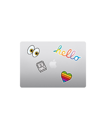 MacBook Air, pohled shora, zav?eny, st?íbrná barva, barevné nálepky kolem loga Apple