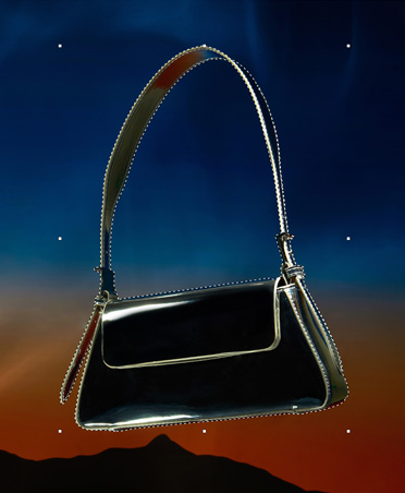Una borsa nera contornata da linee tratteggiate, strumento di selezione, modifica dell’immagine, tramonto con il profilo di alcune montagne
