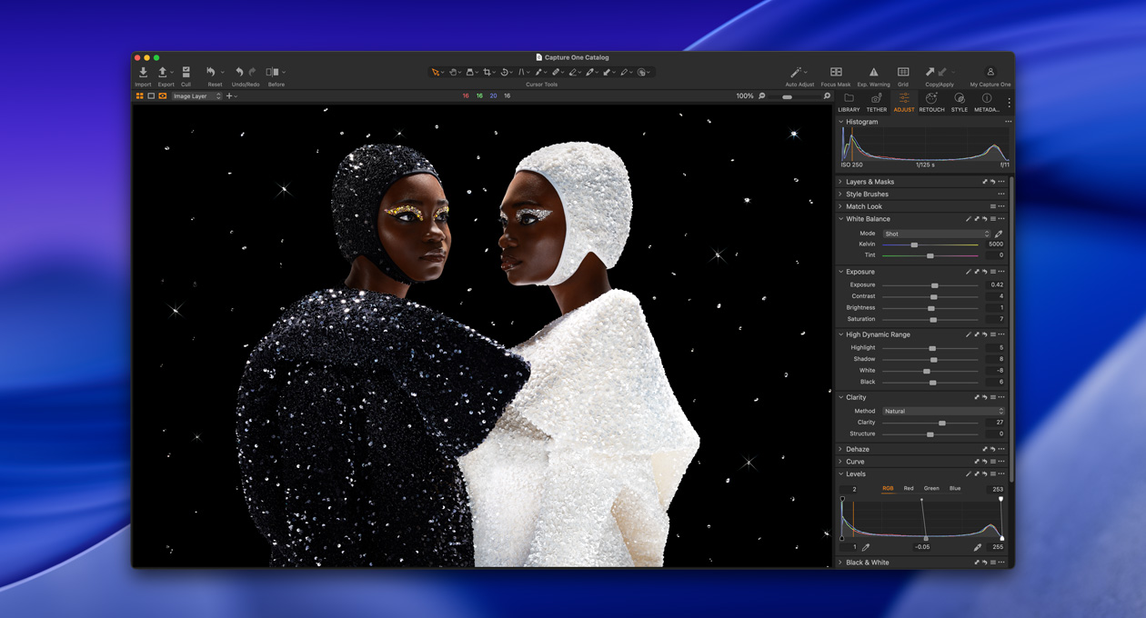 Une personne vêtue de noir se tient de biais à c?té d’une personne vêtue de blanc, illustrant la luminosité et le contraste du Studio Display XDR