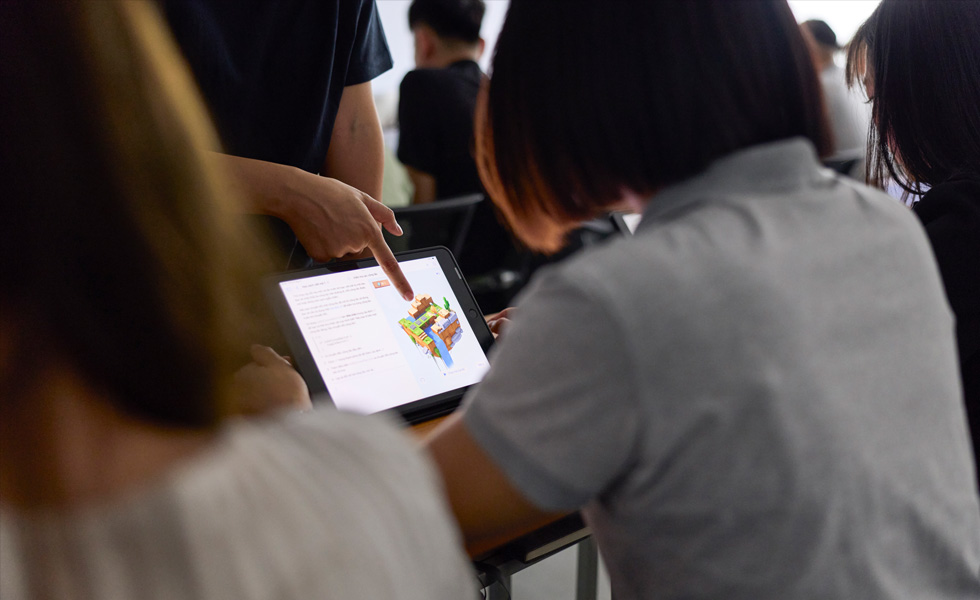 En person deler feedback om en genstand p? en tablet i et klassev?relse
